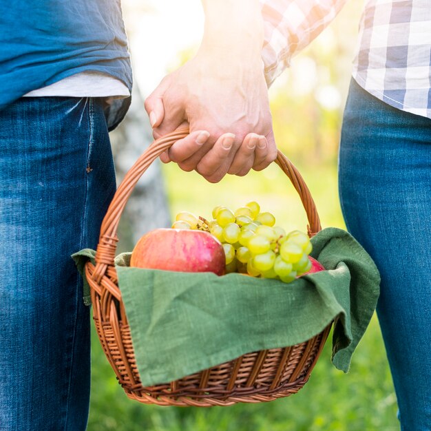 Innamorati con cestino da picnic nel parco