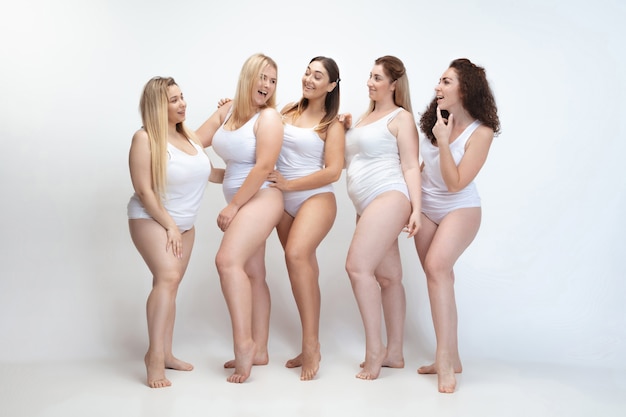 Innamorato di me stesso. Ritratto di belle giovani donne plus size in posa sul bianco