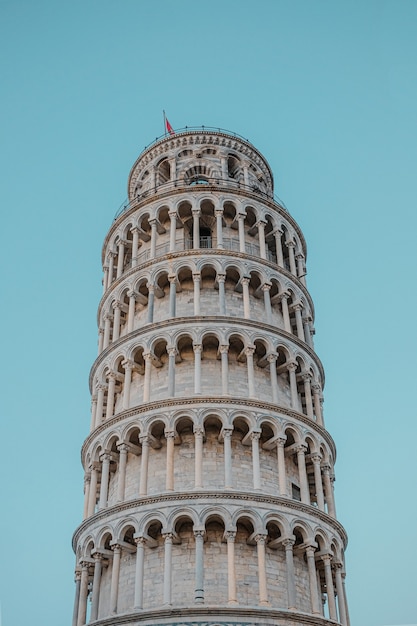 Inquadratura dal basso della bellissima Torre Pendente di Pisa sotto un cielo blu