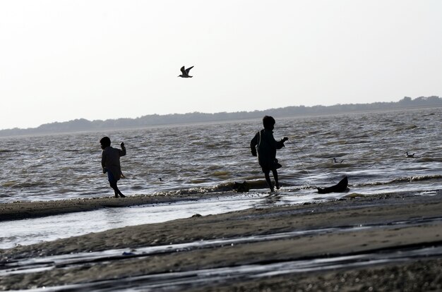 Inquadratura dal basso di bambini che camminano sulla spiaggia