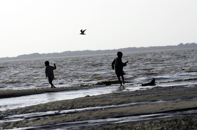 Inquadratura dal basso di bambini che camminano sulla spiaggia