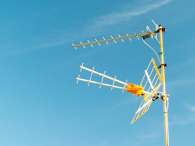 Inquadratura dal basso di un'antenna televisiva catturata in una giornata di sole con cielo sereno