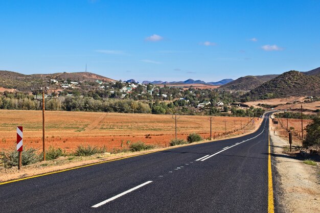 Inquadratura dal basso di un'autostrada circondata da montagne e colline