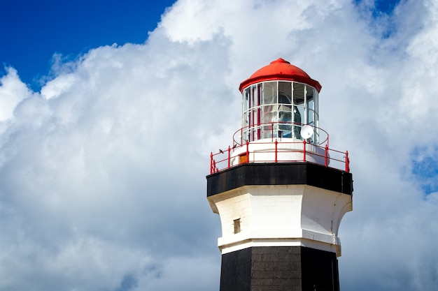 Inquadratura dal basso di un faro sotto la bella nuvola nel cielo