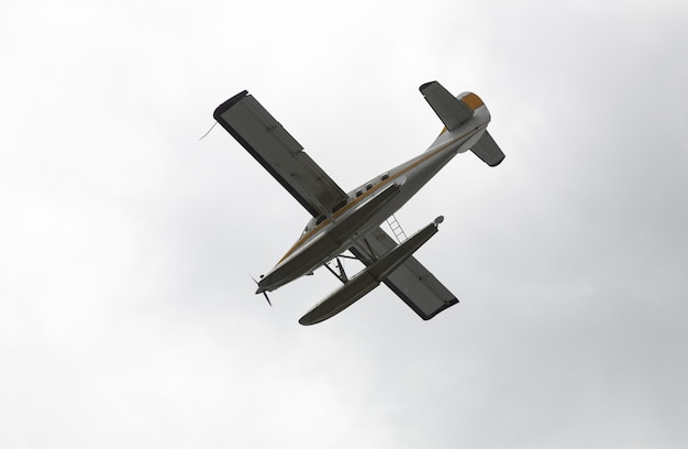 Inquadratura dal basso di un idrovolante che sorvola il cielo sereno