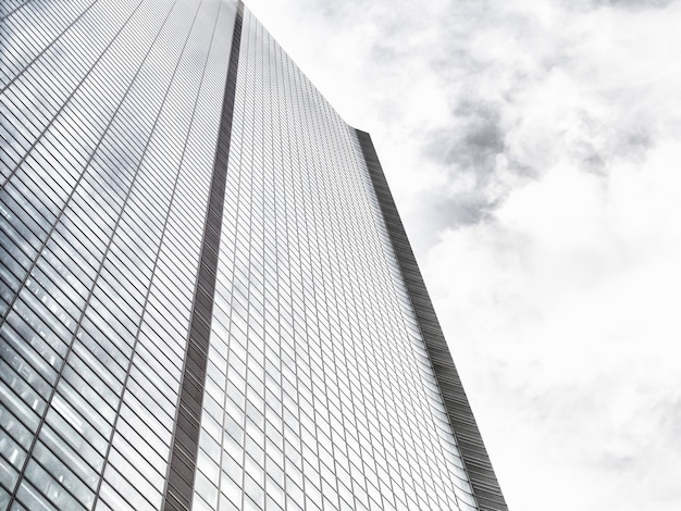 Inquadratura dal basso di un moderno grattacielo di vetro su un cielo nuvoloso