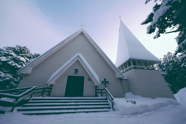 Inquadratura dal basso di una cappella ricoperta di neve spessa in inverno