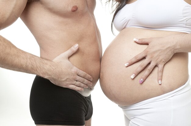 Inquadratura dal basso di una coppia sposata che si aspetta di avere un bambino con lo stomaco che si tocca