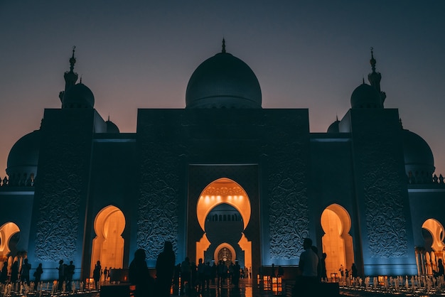 Inquadratura dal basso di una grande moschea di Abu Dhabi con luci incandescenti all'interno di un edificio