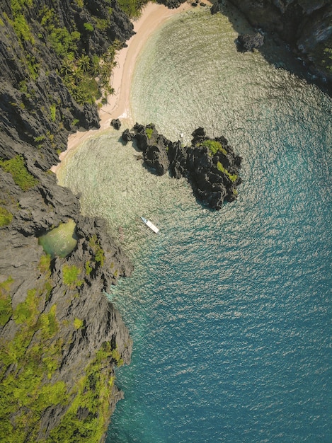 Inquadratura dall'alto dell'oceano e della spiaggia circondata da scogliere coperte di muschio