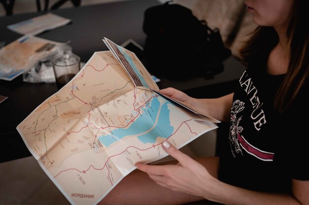 Inquadratura dall'alto di una donna che tiene e legge una mappa per trovare la sua strada
