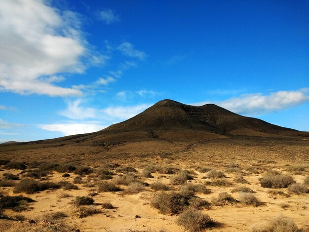 Inquadratura di un deserto arido e una montagna in lontananza nel Parco Naturale di Corralejo, in Spagna