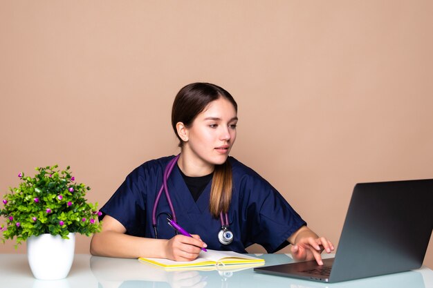 Inquadratura di una dottoressa che parla con i colleghi tramite una videochiamata con un laptop durante la consultazione