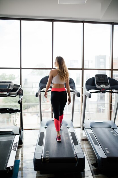 Inquadratura orizzontale della donna che pareggia sul tapis roulant al centro benessere. Donna che lavora in una palestra in esecuzione su un tapis roulant.