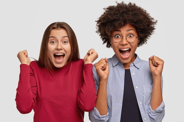 Inquadratura orizzontale di donne felicissime stringono i pugni con felicità