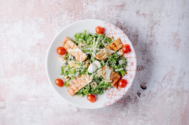 Insalata Caesar con petto di pollo grigliato, parmigiano e pomodorini.