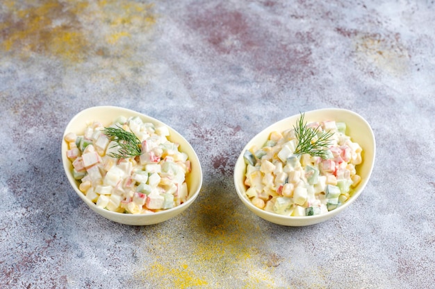 Insalata con bastoncini di granchio, uova, mais e cetriolo.