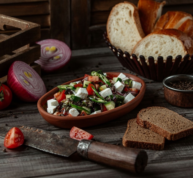 Insalata con formaggio e verdure a cubetti ed erbe