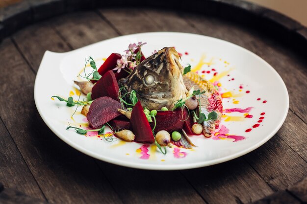 Insalata con testa di pesce sul barile di legno