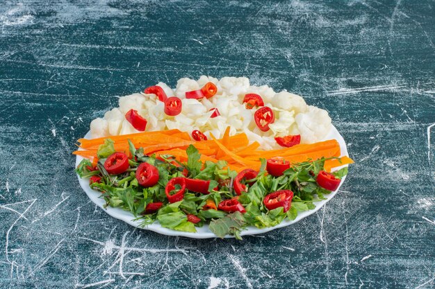 Insalata con varietà di ingredienti tra cui pomodorini, erbe e spezie.