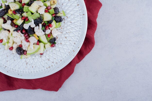 Insalata con verdure, olive nere e chicchi di melograno