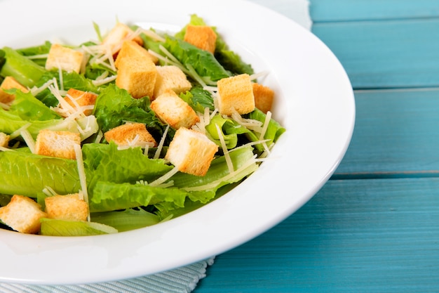 Insalata di Caesar sul tavolo da picnic blu