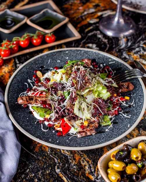 Insalata di carne con lattuga, mais, melograno e formaggio grattugiato