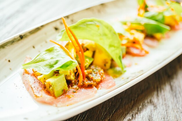 Insalata di carne di pesce fresco crudo con avocado e mango