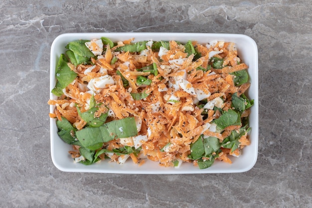 Insalata di carote a fette sul piatto bianco.