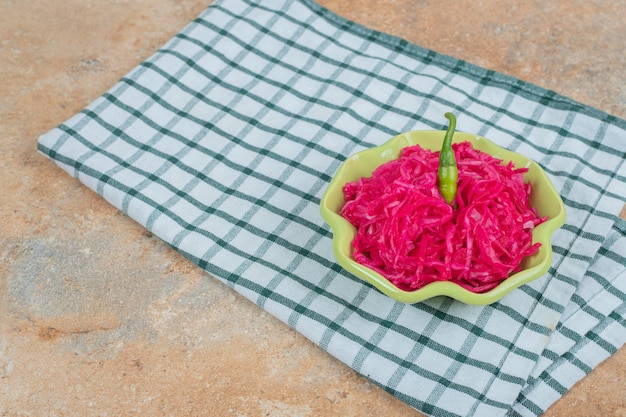 Insalata di crauti rossi in una ciotola verde con tovaglia