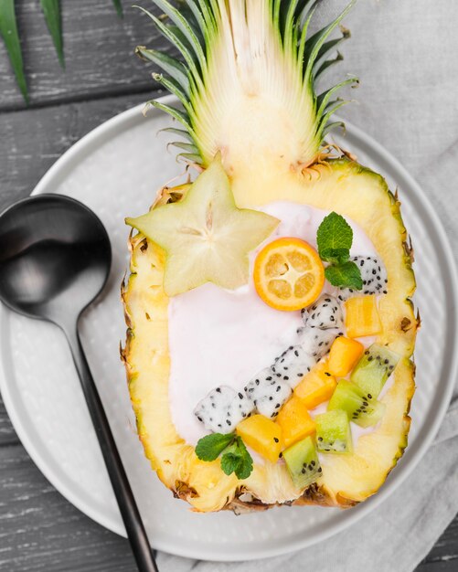 Insalata di frutta a metà di ananas e cucchiaio