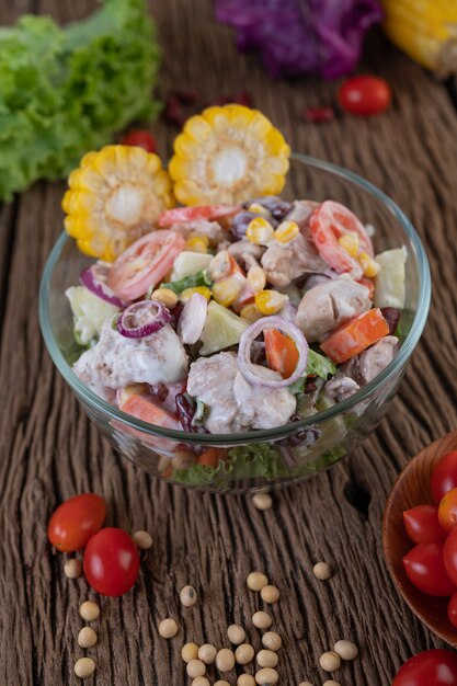 Insalata di frutta e verdura in una tazza di vetro su un pavimento di legno