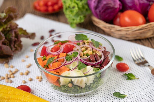 Insalata di frutta e verdura in una tazza di vetro su una terra bianca