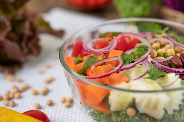 Insalata di frutta e verdura in una tazza di vetro su una terra bianca