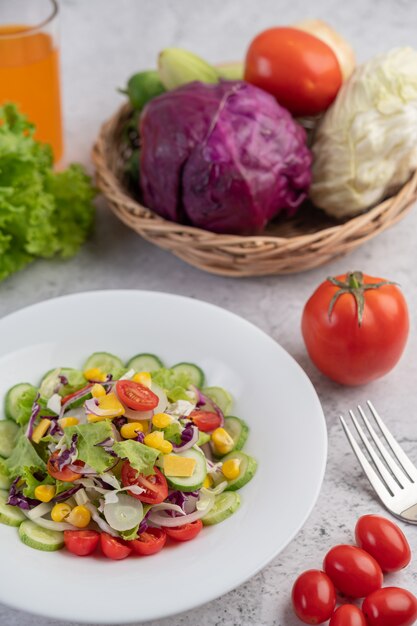 Insalata di frutta e verdura su un piatto bianco.