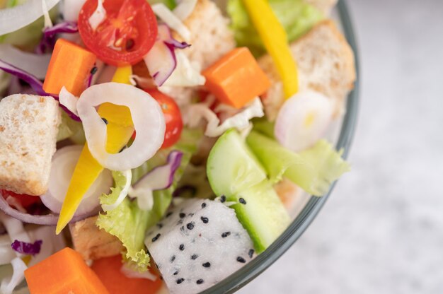 Insalata di frutta e verdura su un piatto bianco.