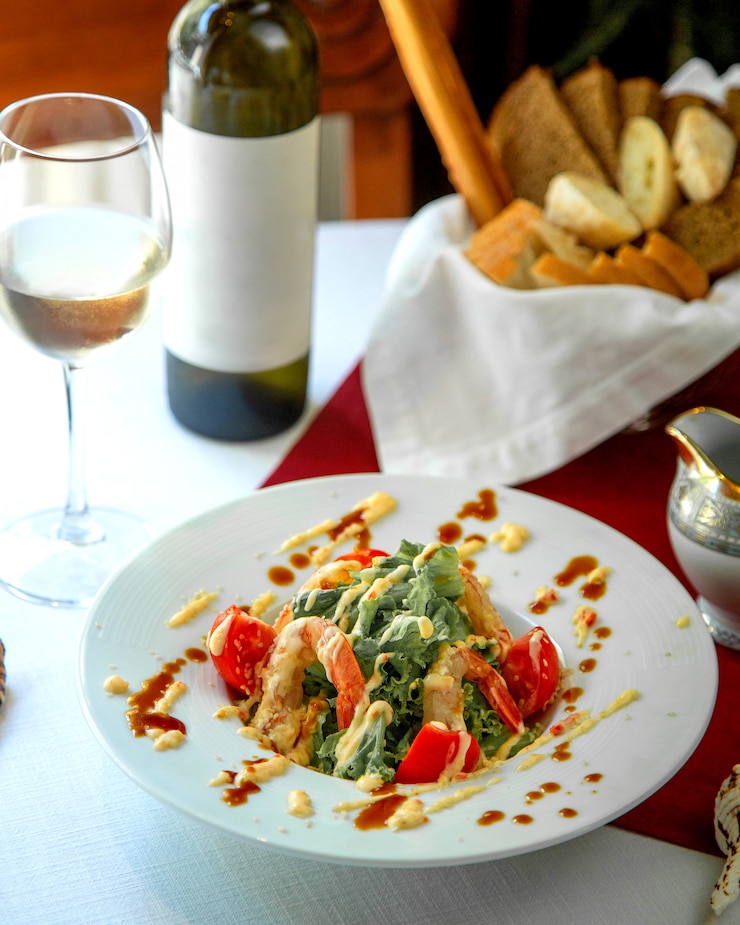 Foto gratuito insalata di gamberi con bicchiere di vino bianco