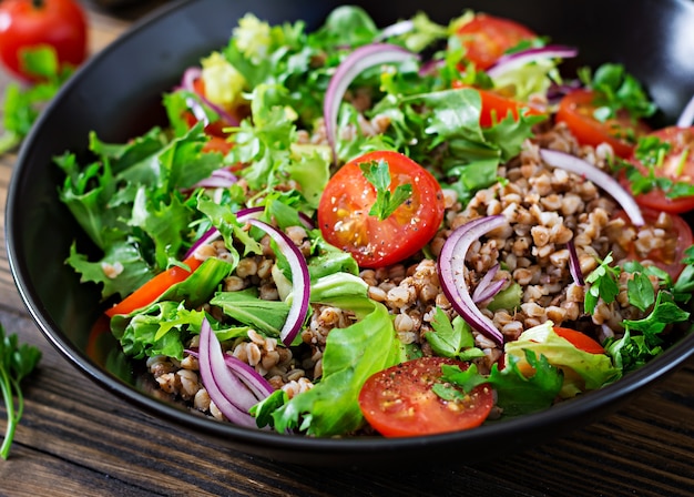 Insalata di grano saraceno con pomodorini, cipolla rossa ed erbe fresche. Cibo vegano. Menu dietetico.