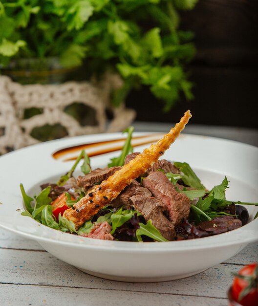 insalata di manzo con rucola, pomodori e grissino con semi di sesamo