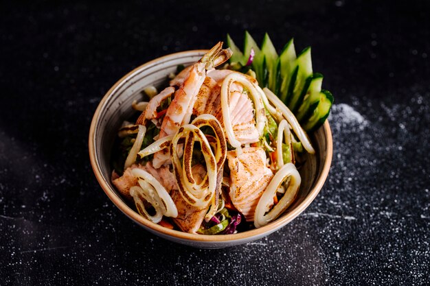 Insalata di mare con salmone fille, granchi e verdure all'interno della ciotola.