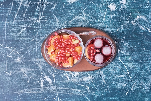 Insalata di melograno con una tazza di bevanda sul blu.