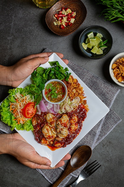 Insalata di ostriche fresca piccante e ingredienti alimentari tailandesi.