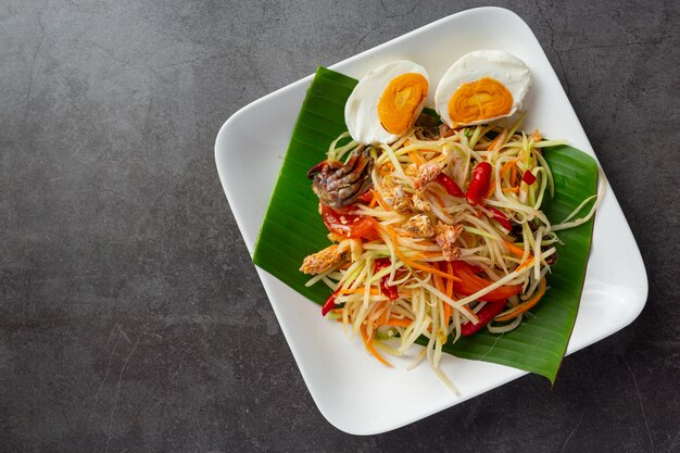 Insalata di papaya servita con spaghetti di riso e insalata di verdure Decorata con ingredienti alimentari tailandesi.