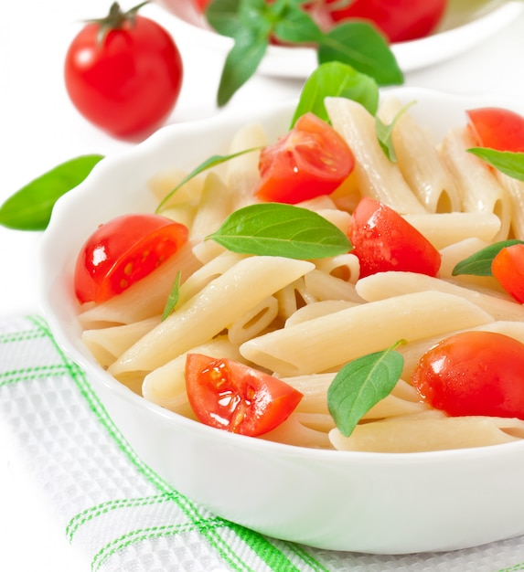 Insalata di pasta con pomodorini e foglie di basilico fresco