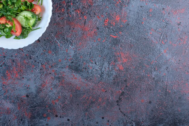 Insalata di pastore mescolata con foglie di prezzemolo sulla tavola nera.