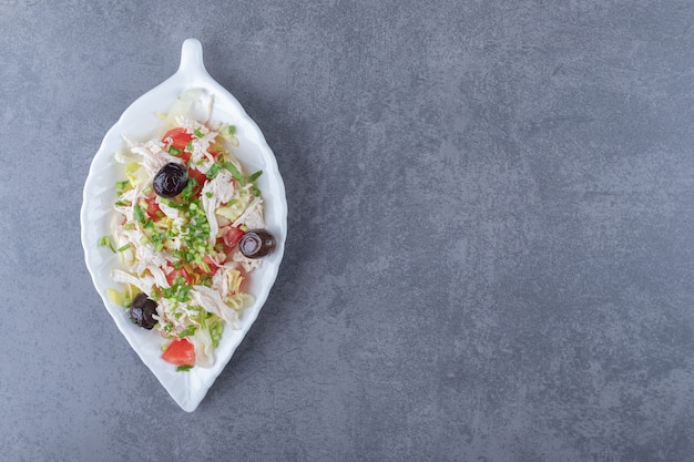 Insalata di pollo a dadini su piatto a forma di foglia.