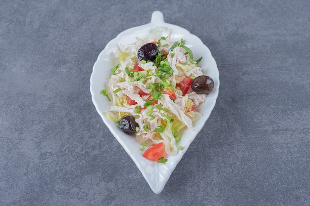 Insalata di pollo fatta in casa su piatto a forma di foglia.