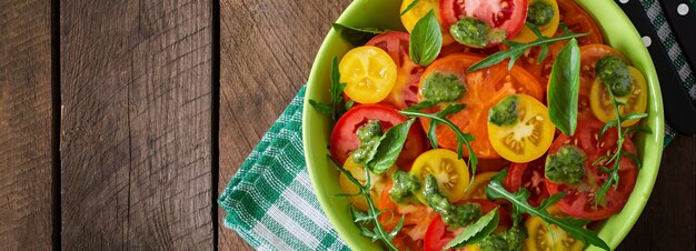 Insalata di pomodori estivi con basilico, pesto e rucola