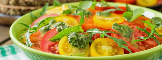 Insalata di pomodori estivi con basilico, pesto e rucola