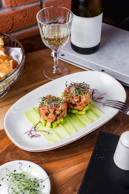 Insalata di salmone con avocado servito con fette di cetriolo e verdure 1